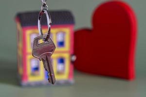 símbolo da casa com chave de metal e miniatura de propriedade, simbolizando a casa própria foto