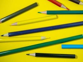 lápis de madeira de cor sobre papel colorido. lápis apontados. ferramenta de desenho. acessórios para a criatividade.