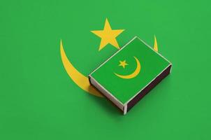 bandeira da Mauritânia é retratada em uma caixa de fósforos que fica em uma grande bandeira foto