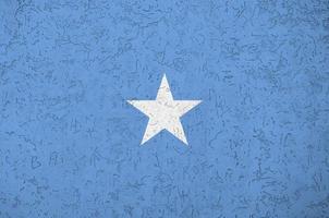 bandeira da Somália retratada em cores de tinta brilhante na parede de reboco em relevo antigo. banner texturizado em fundo áspero foto