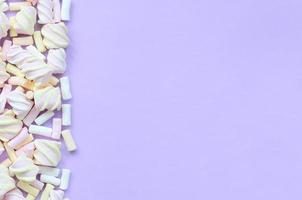 marshmallow colorido disposto em fundo de papel violeta. textura criativa pastel. mínimo foto