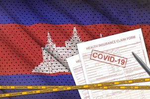 bandeira do camboja e formulário de solicitação de seguro de saúde com carimbo covid-19. conceito de vírus coronavírus ou 2019-ncov foto