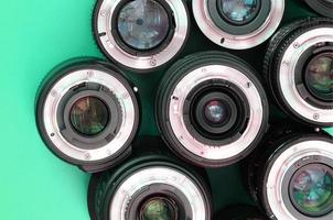 várias lentes fotográficas estão em um fundo turquesa brilhante. espaço de cópia foto