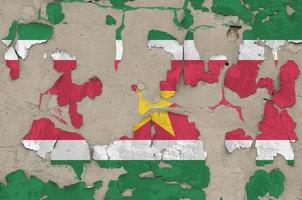 bandeira do suriname retratada em cores de tinta na velha parede de concreto bagunçada obsoleta closeup. banner texturizado em fundo áspero foto