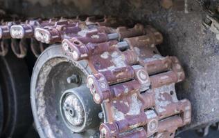 trilhas quebradas enferrujadas com rolos de esteira de um tanque destruído. tanque de batalha russo destruído durante os combates durante a invasão russa da ucrânia, 2022. restos de equipamento militar russo. foto