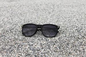 óculos de sol em closeup de fundo de areia foto