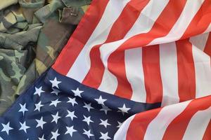 bandeira dos estados unidos da américa e jaqueta de uniforme militar dobrada. bandeira de fundo conceitual de símbolos militares para feriados patrióticos americanos foto