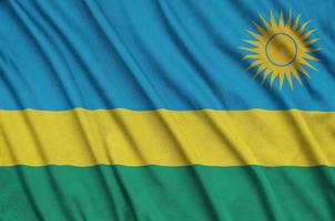 A bandeira de Ruanda é retratada em um tecido esportivo com muitas dobras. bandeira da equipe esportiva foto
