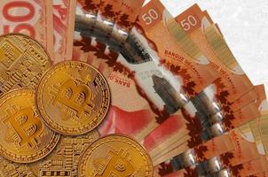 50 notas de dólares canadenses e bitcoins dourados. conceito de investimento em criptomoeda. mineração ou negociação de criptomoedas foto
