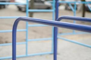 barras esportivas em azul no fundo de um campo de esportes de rua para treinamento de atletismo. equipamento de ginástica esportiva ao ar livre. foto macro com foco seletivo e fundo extremamente desfocado