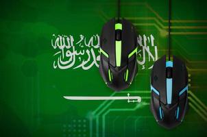 bandeira da arábia saudita e dois ratos com luz de fundo. jogos cooperativos online. time de esportes cibernéticos foto