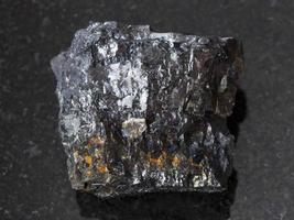 pedra de carvão betuminoso cru em fundo escuro foto