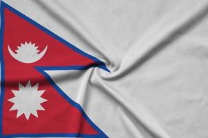 A bandeira do nepal é retratada em um tecido esportivo com muitas dobras. bandeira da equipe esportiva foto