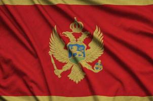 a bandeira de montenegro é retratada em um tecido esportivo com muitas dobras. bandeira da equipe esportiva foto