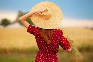 garota ruiva de vestido vermelho em campo de trigo