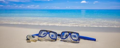 esporte de verão, praia atividade praia banner recreativo. óculos de mergulho equipamento de snorkel na areia branca perto das ondas do mar. férias panorâmicas e fundo de viagens recreativas. diversão liberdade aventura estilo de vida foto