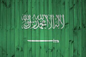 bandeira da arábia saudita retratada em cores brilhantes de tinta na parede de madeira velha. banner texturizado em fundo áspero foto