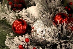 ornamentos festivos de vermelho e prata na árvore de natal reunida foto