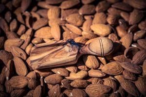 uma pilha de amêndoas e um glas com óleo de amêndoa foto