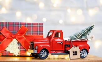 carro retrô vermelho com uma árvore de natal decora com a chave da casa na caminhonete para o natal. compra de uma casa, mudança, hipoteca, empréstimo, imóveis, clima festivo, ano novo foto