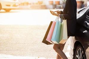 pessoa usando smartphone segurando sacolas de compras foto