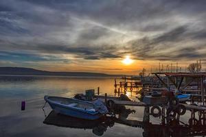 emocionante pôr do sol no porto com barcos foto
