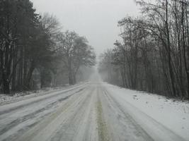 estrada lateral na floresta durante a temporada de inverno coberta de neve e gelo foto