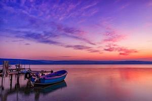 bela composição de luz e humor do barco ao pôr do sol foto