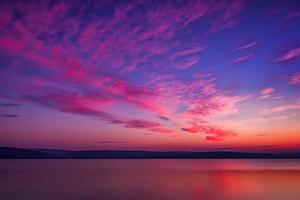 soberbo pôr do sol com reflexo da água foto