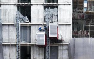 engenheiros reparando elevadores no canteiro de obras foto