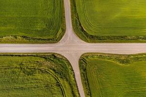 vista aérea de uma encruzilhada no cascalho do país sem estrada de tráfego entre campos foto