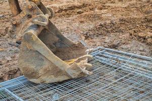 caçamba pesada industrial de metal de ferro grande de escavadeira, escavadeira, equipamento de construção especializado para reparo de estradas e escavação da terra foto