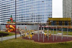 novo parque infantil ao ar livre seguro moderno ao ar livre com equipamentos de ginástica e brinquedos em um novo distrito da cidade no pátio de um novo edifício foto