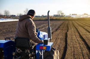 o trator está cultivando o solo no campo agrícola. agricultura. agronegócio agropecuário. preparando-se para cortar linhas para a próxima estação de semeadura na primavera. suavizando e melhorando as qualidades do solo. foto