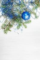 uma bola de natal azul e galho de árvore em papel em branco foto