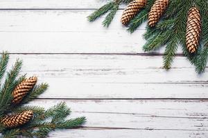 galhos de abeto e cones em fundo branco de madeira, postura plana de natal, copie o espaço foto