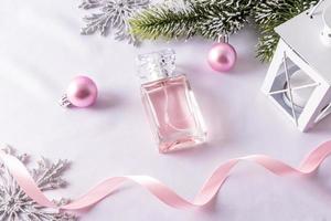 um frasco de perfume feminino floral no fundo das decorações de natal. o conceito de apresentação de um novo ano de uma fragrância ou presente. foto