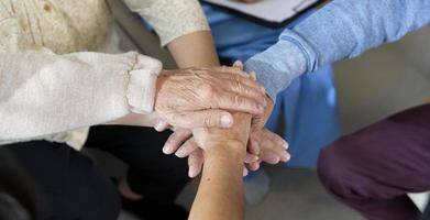 vista superior de idosos de mãos dadas juntos no centro de saúde de idosos, conceito de cuidados de saúde de idosos, terapia de grupo. foto