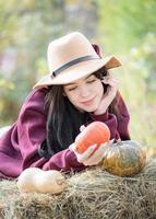 jovem feliz com abóbora no jardim de outono foto