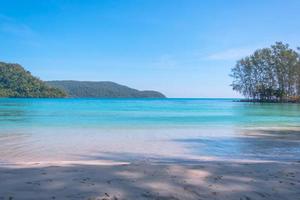 belo mar na praia tropical como paisagem de verão com céu azul para viajar nas férias relaxar no verão foto