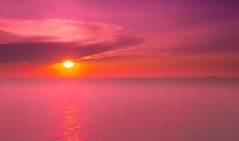 marinhas do belo pôr do sol na praia do mar com céu rosa de férias foto