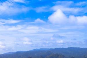 árvore verde e montanhas no céu azul com nuvens, fundo bonito foto