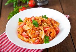 macarrão fettuccine com camarão, tomate e ervas foto