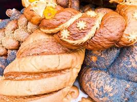 textura de pães brancos saborosos luxuriantes de trigo marrom avermelhado, pão, pães de papoula pretos. o fundo foto