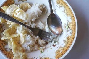 restos de comida e pratos sujos na mesa do restaurante. comida que não acabou. arroz e chips de melinjo. foto