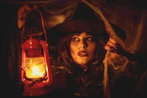 bruxa com lanterna acesa na névoa mágica foto