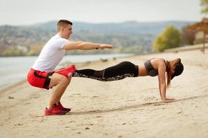 casal se exercitando na praia foto