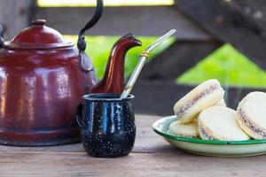 mate e chaleira com um prato de alfajores e infusão de erva-mate no campo argentino foto