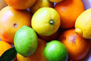 várias frutas cítricas em uma tigela de cerâmica foto