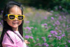 menina asiática de vestido rosa com óculos escuros foto